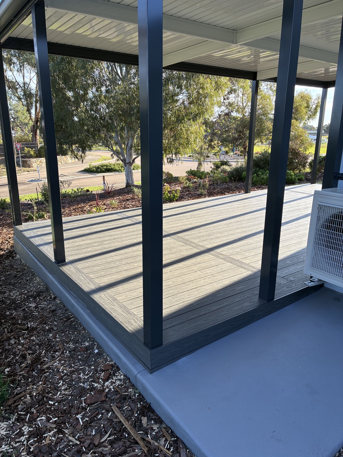 Covered composite deck with steel posts and street outlook by NPD Building Solutions